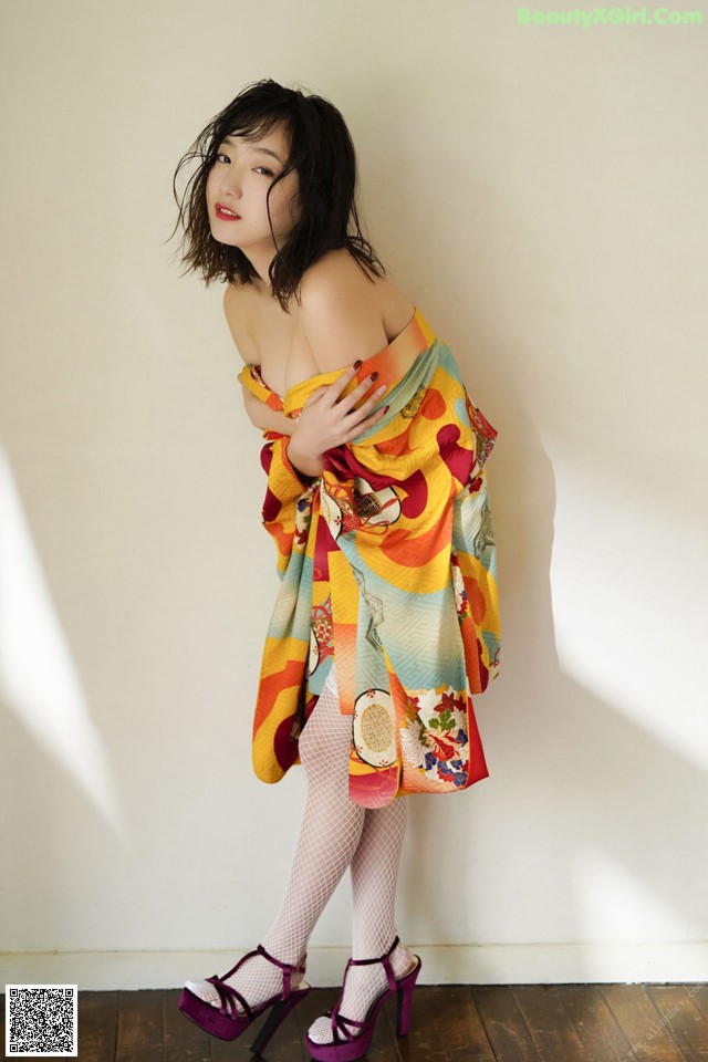 A woman in a colorful dress posing for a picture.