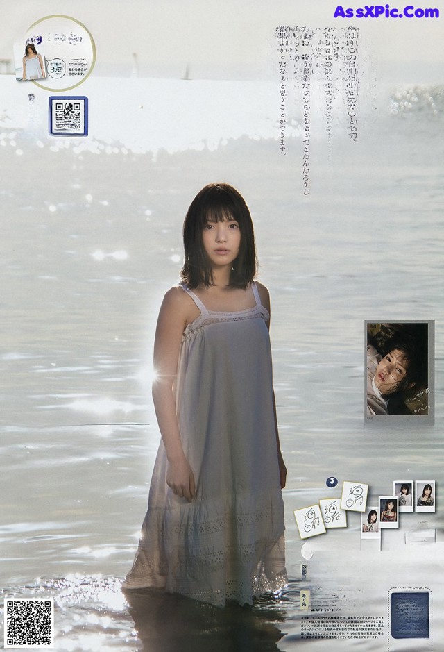 A woman in a white dress standing in the water.