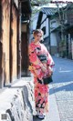 A woman in a kimono is walking down the street.